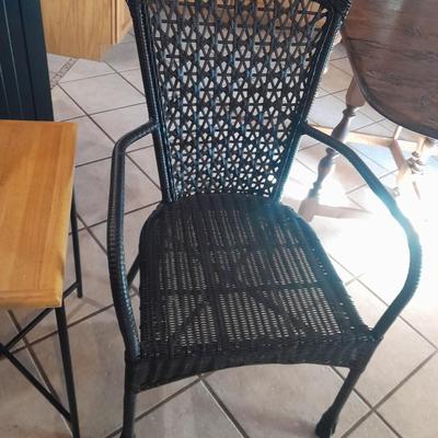 Metal framed end table with wood or glass top and a black woven plastic armchair