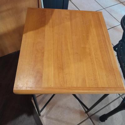 Metal framed end table with wood or glass top and a black woven plastic armchair