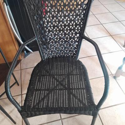 Metal framed end table with wood or glass top and a black woven plastic armchair