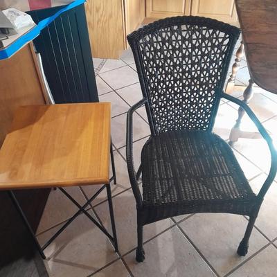 Metal framed end table with wood or glass top and a black woven plastic armchair