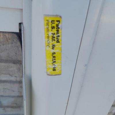 Glass storm door with brass colored trim