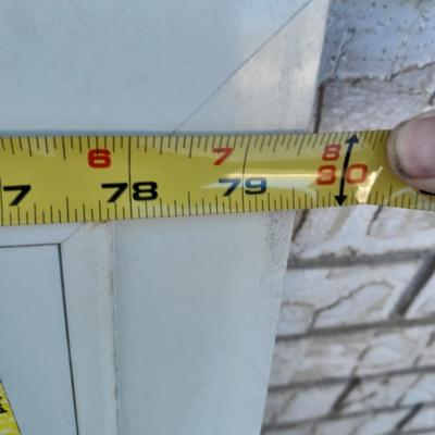 Glass storm door with brass colored trim