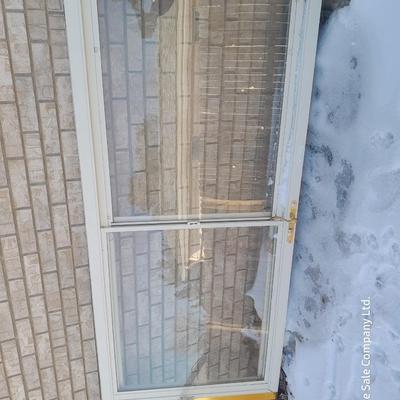 Glass storm door with brass colored trim