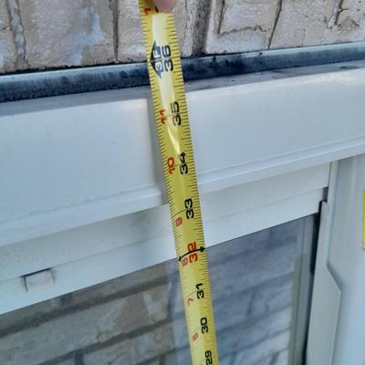 Glass storm door with brass colored trim