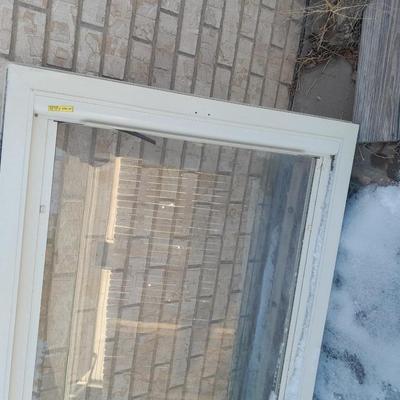 Glass storm door with brass colored trim