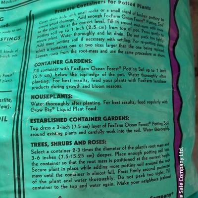 Rope handled barrel with new Fox farm potting soil, weed claw, and other gardening items