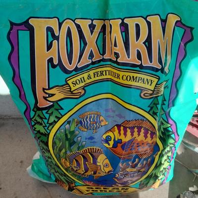 Rope handled barrel with new Fox farm potting soil, weed claw, and other gardening items
