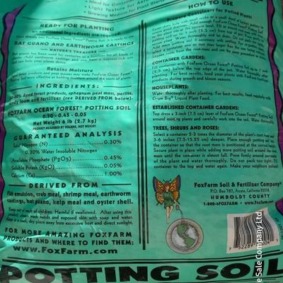 Rope handled barrel with new Fox farm potting soil, weed claw, and other gardening items