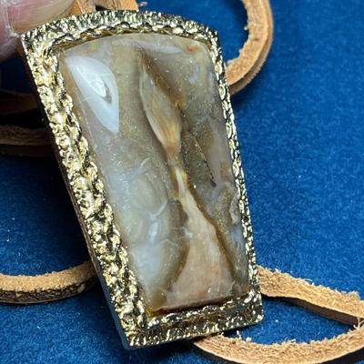 LARGE POLISHED STONE WITH REAL RAWHIDE STRINGS BOLO TIE
