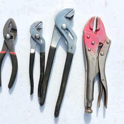 Assortment of black handled Pliers and an adjustable wrench