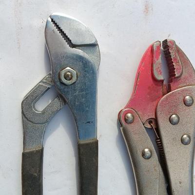 Assortment of black handled Pliers and an adjustable wrench