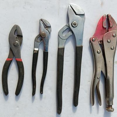 Assortment of black handled Pliers and an adjustable wrench
