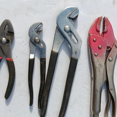Assortment of black handled Pliers and an adjustable wrench