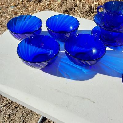BLUE GLASS FOUR BOWLS AND FOUR CUP & SAUCERS