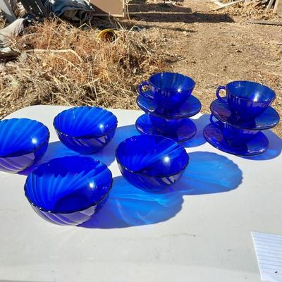 BLUE GLASS FOUR BOWLS AND FOUR CUP & SAUCERS