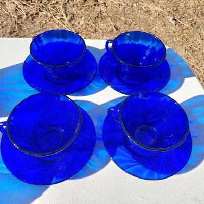 BLUE GLASS FOUR BOWLS AND FOUR CUP & SAUCERS