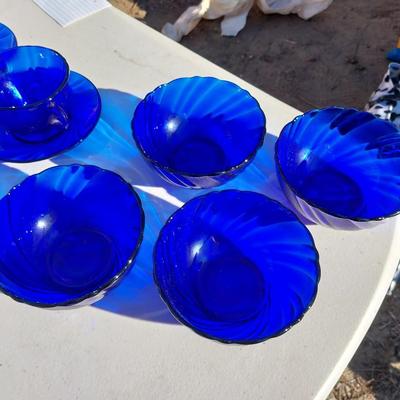 BLUE GLASS FOUR BOWLS AND FOUR CUP & SAUCERS