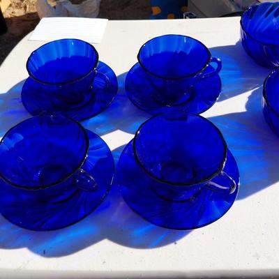 BLUE GLASS FOUR BOWLS AND FOUR CUP & SAUCERS