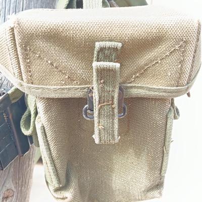 Military issued suspenders with a canteen and an assortment of pouches for ammo and magazines and more.