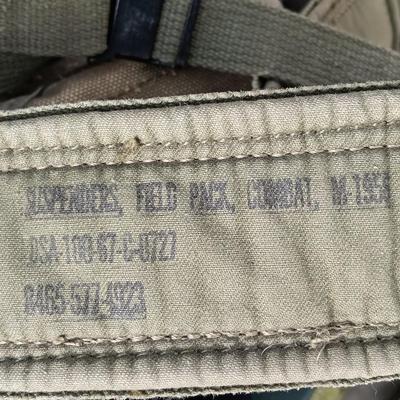 Military issued suspenders with a canteen and an assortment of pouches for ammo and magazines and more.