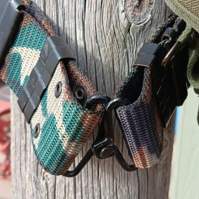 Military issued suspenders with a canteen and an assortment of pouches for ammo and magazines and more.