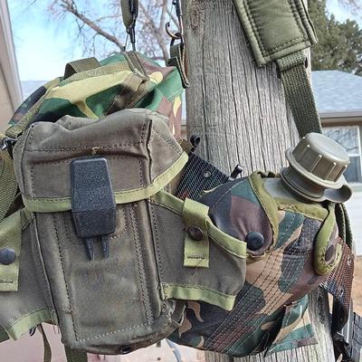 Military issued suspenders with a canteen and an assortment of pouches for ammo and magazines and more.