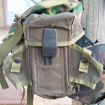 Military issued suspenders with a canteen and an assortment of pouches for ammo and magazines and more.