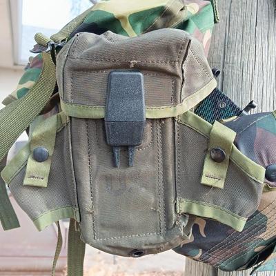 Military issued suspenders with a canteen and an assortment of pouches for ammo and magazines and more.