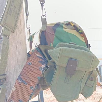Military issued suspenders with a canteen and an assortment of pouches for ammo and magazines and more.
