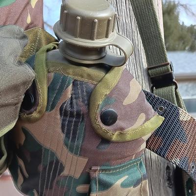 Military issued suspenders with a canteen and an assortment of pouches for ammo and magazines and more.
