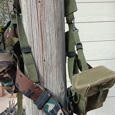 Military issued suspenders with a canteen and an assortment of pouches for ammo and magazines and more.