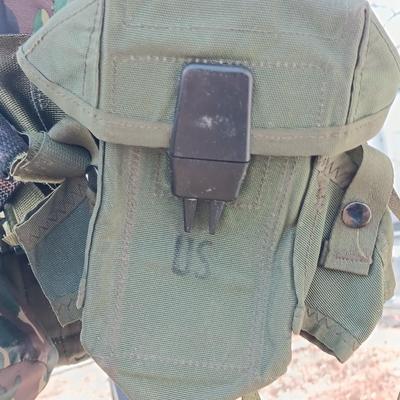 Military issued suspenders with a canteen and an assortment of pouches for ammo and magazines and more.