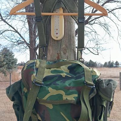 Military issued suspenders with a canteen and an assortment of pouches for ammo and magazines and more.