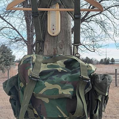 Military issued suspenders with a canteen and an assortment of pouches for ammo and magazines and more.