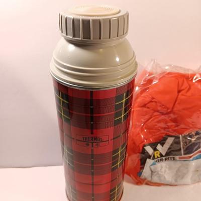 Vintage thermos with raincoat aluminum drinking cup and a folding coleman shovel pick