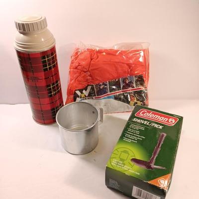 Vintage thermos with raincoat aluminum drinking cup and a folding coleman shovel pick