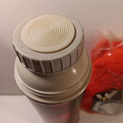 Vintage thermos with raincoat aluminum drinking cup and a folding coleman shovel pick