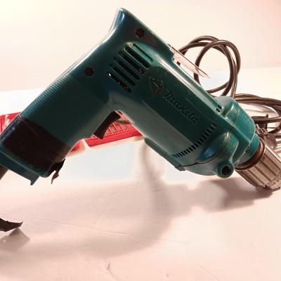 Makita 1/2" electric drill with assortment of drill bits