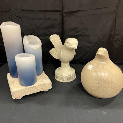 2 CERAMIC BIRDS AND A GROUP OF CANDLES ON A PLASTER BASE