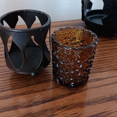 Butterfly pillar candle holders with small metal candle votive with amber glass insert.