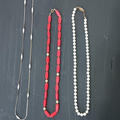 Two beaded necklaces and a gold chain and pearl like necklace