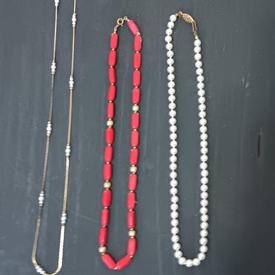 Two beaded necklaces and a gold chain and pearl like necklace