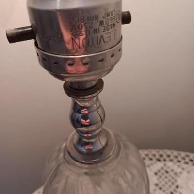 Small covered accent table with vintage lamp and glass vase