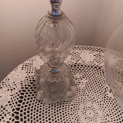 Small covered accent table with vintage lamp and glass vase
