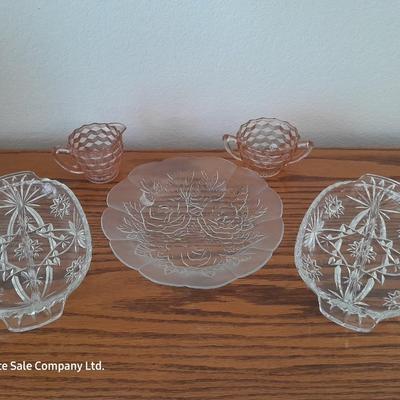 Pink depression glass with two divided pressed glass dishes and a rose patterned dish