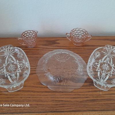 Pink depression glass with two divided pressed glass dishes and a rose patterned dish