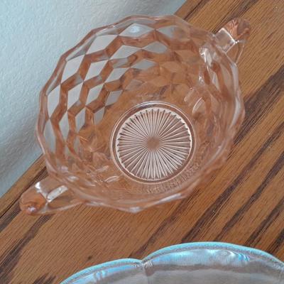 Pink depression glass with two divided pressed glass dishes and a rose patterned dish