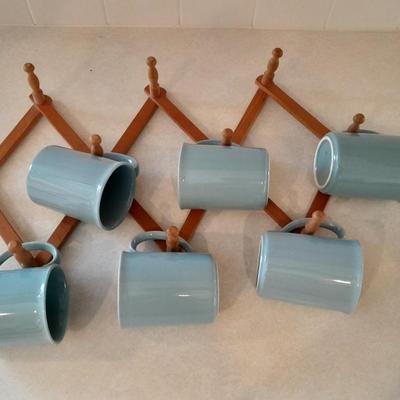 Six matching Corning Mugs with wooden wall hung mug holder.