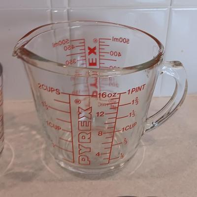 Two glass measuring cups - kitchen utensils - flour sifter