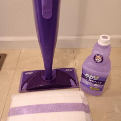 Swiffer wet jet mop with partial bottle of cleaner and few disposable mop pads